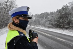 policjantka przy drodze pada śnieg