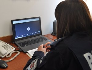 policjantka przed laptopem w trakcie lekcji z uczniami