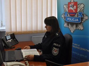 policjantka przy biurku z laptopem w trakcie lekcji online z uczniami